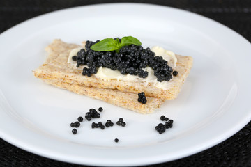 Slices of bread with butter and black caviar