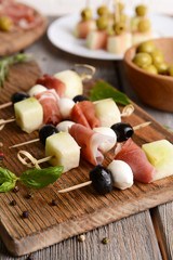 Delicious melon with prosciutto on table close-up