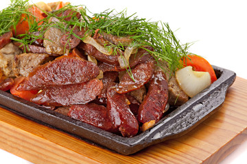 A mixture of various roasted meat with vegetables and herbs serv