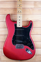 Fototapeta na wymiar Red guitar on wooden background