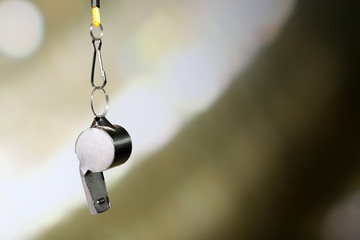Sport metal whistle on color background