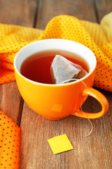Cup of tea with tea bag on wooden table close-up