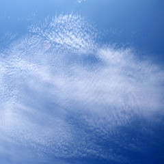 layer of broken stratus clouds under deep blue sky