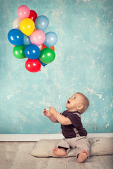 Fototapeta na wymiar kleines Kind spielt mit Luftballons
