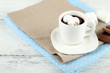 Hot chocolate with marshmallows in mug, on wooden background