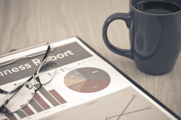 Business report. Cup of coffee and document.