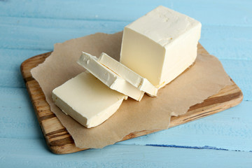 Fresh butter on cutting board, on color wooden background