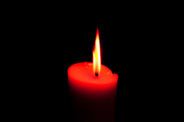 A burning candle in dark.
