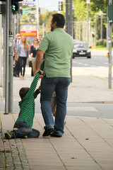Padre levantando a su hijo enfadado del suelo