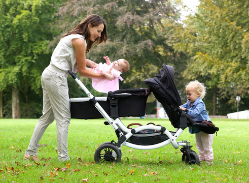 Mother and daughters with pram outdoors