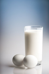 A glass of fresh milk and two eggs