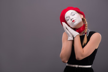 Fototapeta na wymiar Waist-up portrait of young mime girl showing something