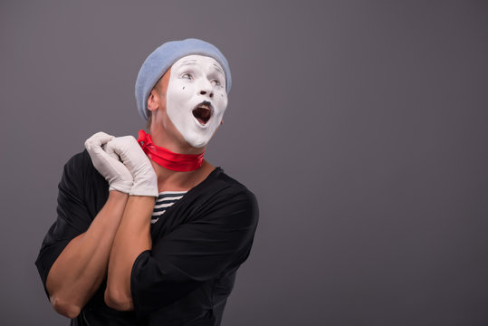 Portrait of young mime boy showing something with his hands