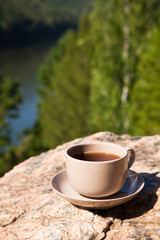 Cup on big stone over nature background