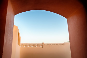 Looking Through Archway at Wall and Blue Sky