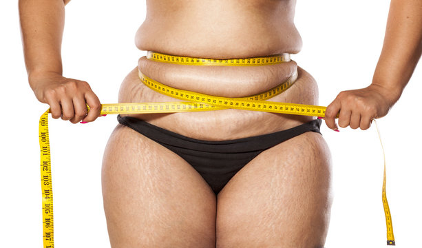 very fat woman measure her waist with tape