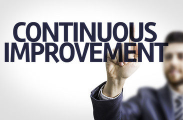 Business man pointing the text: Continuous Improvement