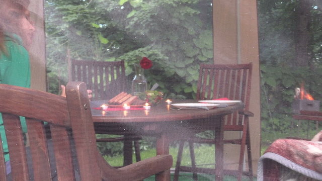Lonely woman sit near table with burn candle and drink in bower