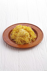 chinese dry noodle in wooden dish on white background