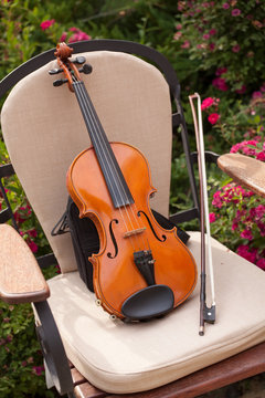 violin and bow on a chair in the garden