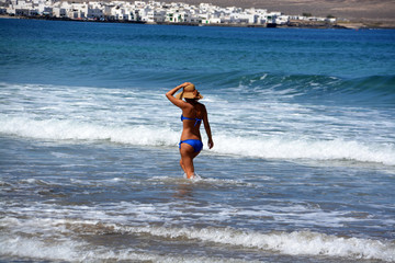 mujer caminando por la playa de famara en lanzarote