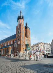 Fototapeta na wymiar Horse carriages on market square, Mariacki Church, Krakow