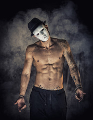 Shirtless man dancer or actor with creepy, scary mask