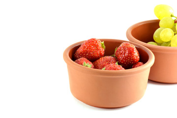 Grapes and strawberries in a bowl, isolated on white