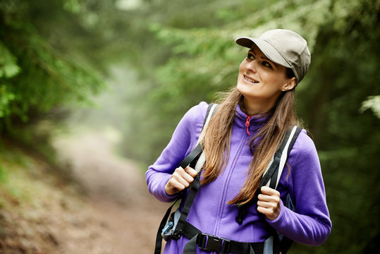 Woman with backpack hiking into the forest