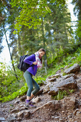 Woman with backpack hiking into the forest