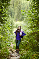 Woman with backpack hiking into the forest