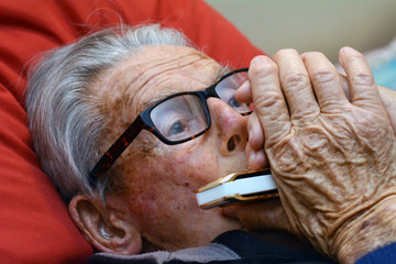 Old man play harmonica