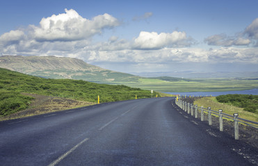 Curved asphalt road in high mountains of Iceland