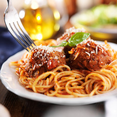 eating a plate of spaghetti and meatballs with fork