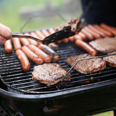 flipping hamburger on charcoal grill