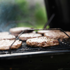 hamubrger patties on a charcoal grill