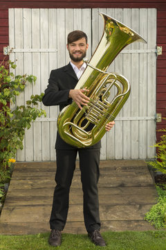 Male musician smiling with tuba