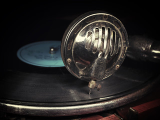 Head with an old gramophone needle on the vinyl disc © plus69