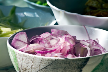Chopped shallots in a bowl tiles.