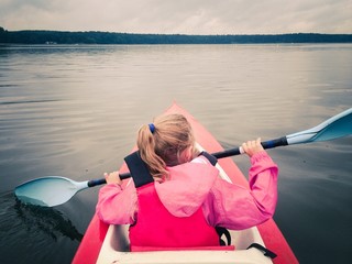 Little girl in kayak on a lake