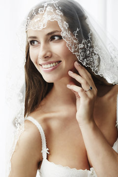 Young bride in wedding veil, studio shot .