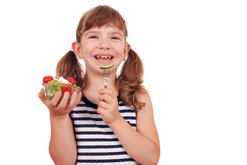 happy little girl eating salad