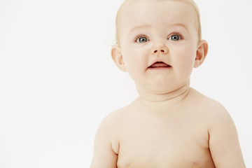 Young baby girl looking away, studio.