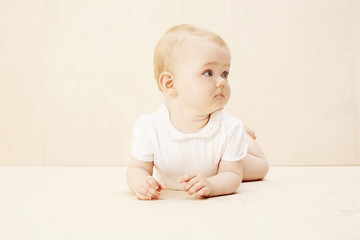 Fototapeta premium Baby girl looking away, studio shot.