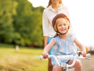 Smiling baby girl riding bicycle