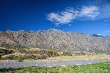 Cloudscape above mountain and green field