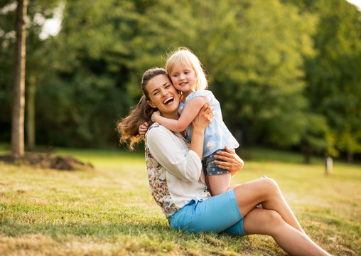 Portrait Of Happy Mother And Baby Girl Hugging In Park