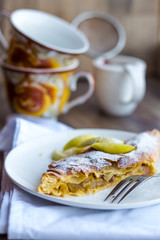 apple strudel on a white plate, cup, .dark background
