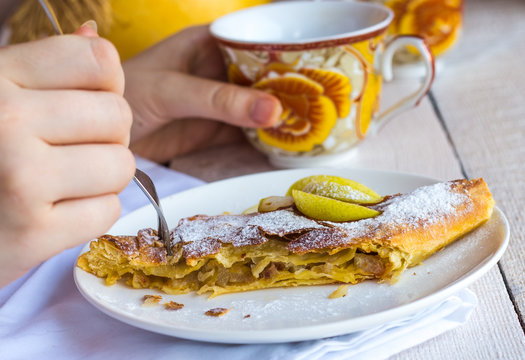 eat apple strudel on a white plate, hands