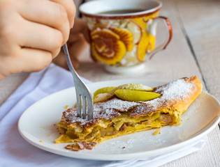 eat apple strudel on a white plate, hands, .fork